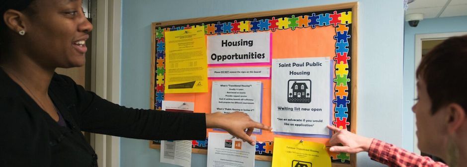 Guest Resourses 2 women looking at Housing Opportunities bulletin board