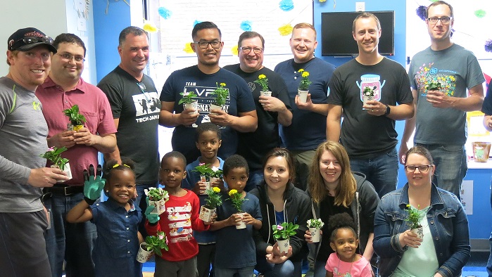 volunteer group - 12 adults pose with 5 children