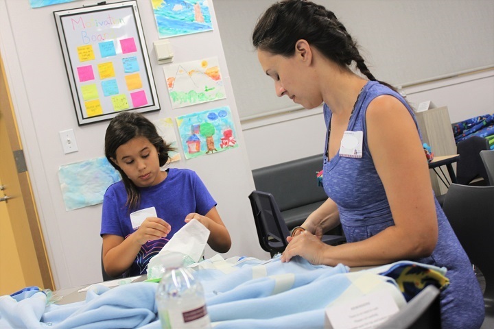 mom & daughter work on tie-blanket and wipes projects at Families Volunteering Together