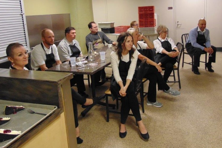 Current & former staff seated and listening to Volunteer Dinner program