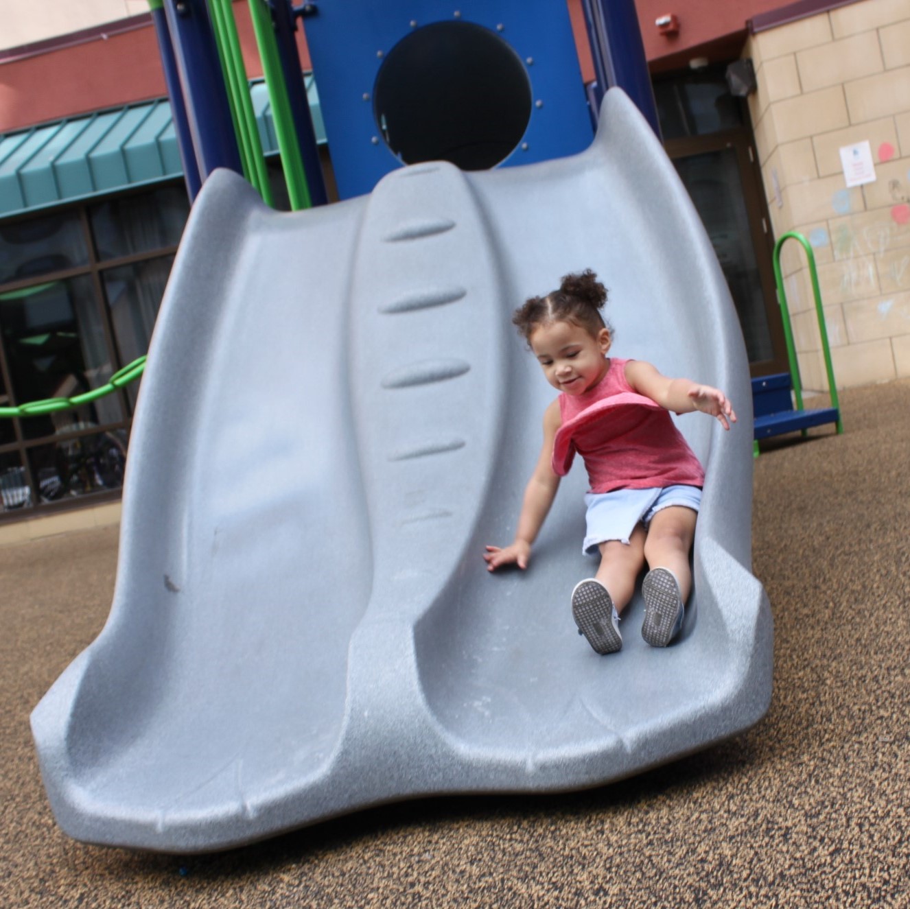 Girl sliding down the new slide