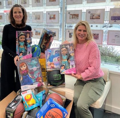 2 women posing with about a dozen new toys