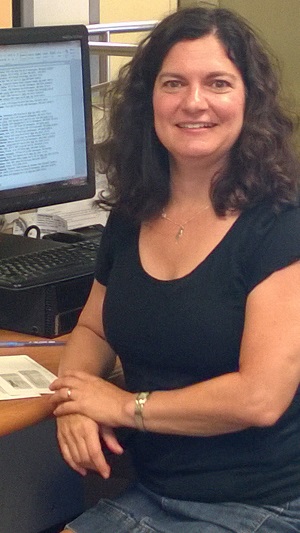 Jane posing at desk in front of computer