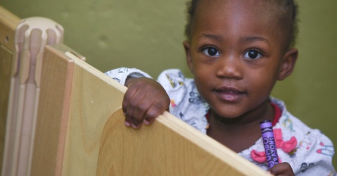 preschool girl with crayon, looking up