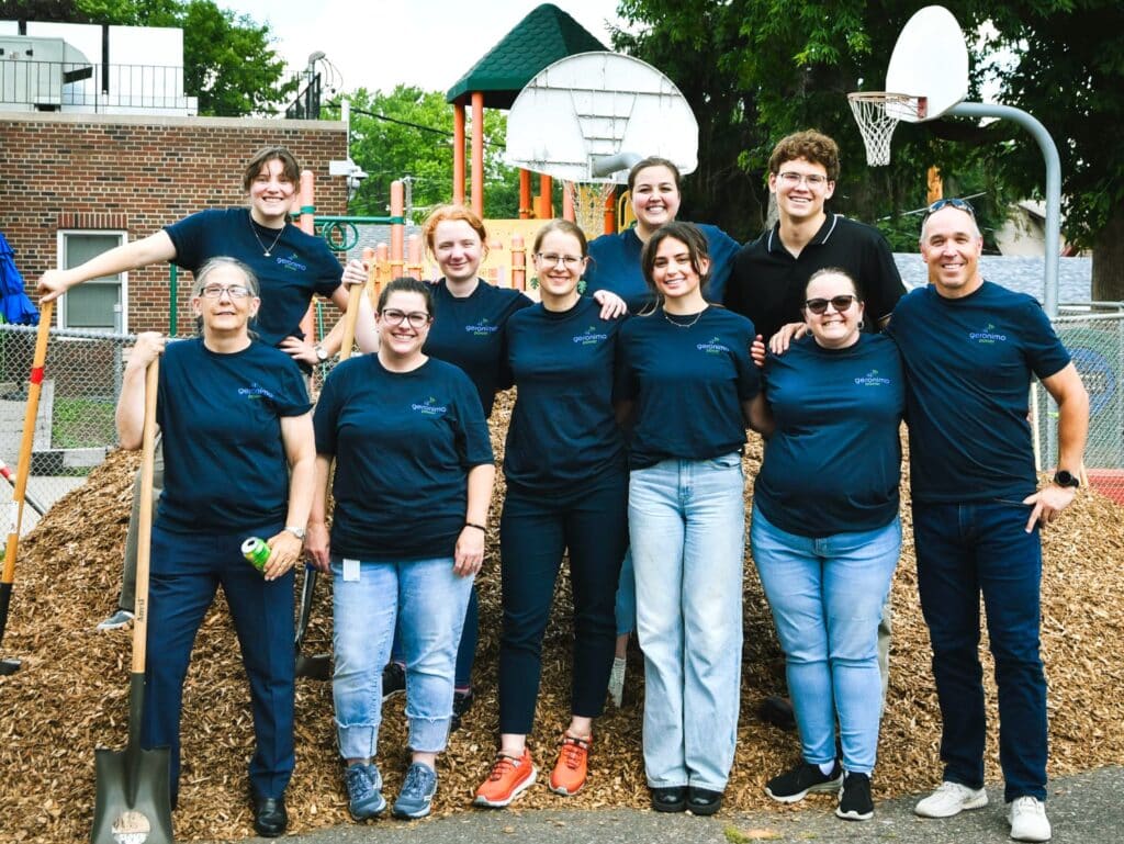 group of nine volunteers and pile of leaves they raked