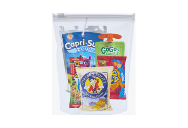 A clear plastic bag is filled with chips, peanut butter crackers, apple sauce, and Capri-Sun.