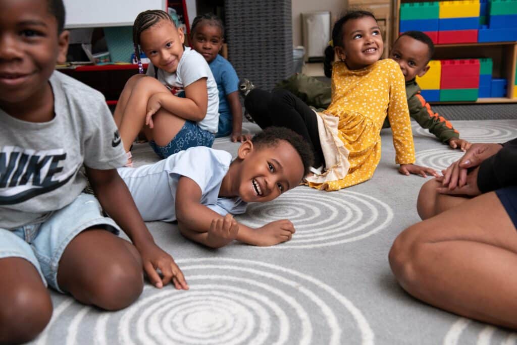preschool children playing on the floor in a circle
