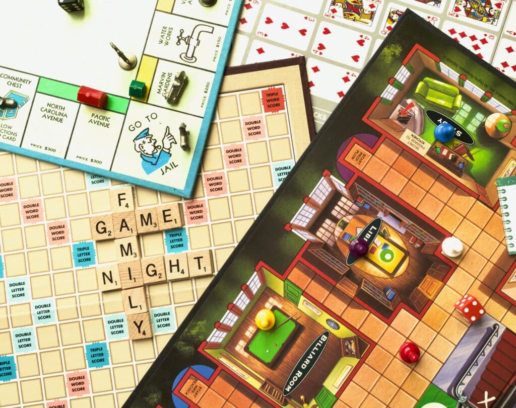 4 different board games overlapping including Monopoly, Clue, and Scrabble